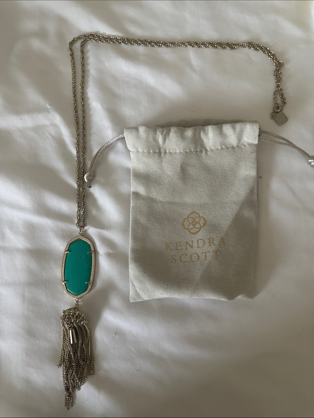 Kendra Scott long gold necklace with teal stone and tassel